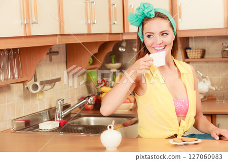 Girl with gingerbread cookies drinking tea coffee. 127060983