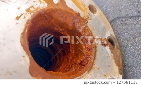 Rusty Artesian Well Pipe Showing Clay Deposits at a Natural Water Source 127061115
