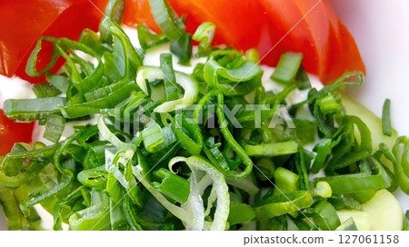 Fresh Salad With Tomatoes, Onions, and Vibrant Greens Prepared for a Healthy Meal 127061158