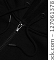 Detail of a black sweatshirt with a hood on a zipper with drawstrings and metal fittings background 127061378