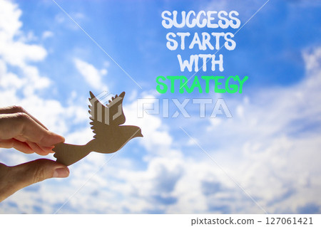 Success starts with strategy symbol. Concept words Success starts with strategy. Beautiful blue sky and clouds background. Business and success starts with strategy concept. Copy space. 127061421