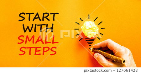 Start with small steps symbol. Concept words phrase Start with small steps on beautiful paper. Businessman's hand. Beautiful orange background. Business Start with small steps concept. Copy space Start with small steps symbol. Concept words phrase Start with small steps on beautiful paper. Businessman's hand. Beautiful orange background. Business Start with small steps concept. Copy space 127061428