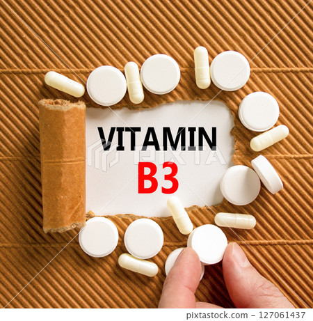 Vitamin B3 niacin symbol. Concept words Vitamin B3 on beautiful white paper. White pills tablets. Doctor's hand. Beautiful brown background. Medical healthy lifestyle Vitamin B3 niacin concept. 127061437