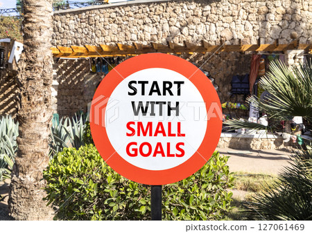 Start with small goals symbol. Concept words phrase Start with small goals on beautiful road sign. Beautiful palm tree background. Business Start with small goals concept. Copy space. 127061469
