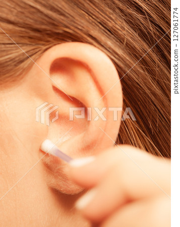 Woman cleaning ear with cotton swabs closeup 127061774