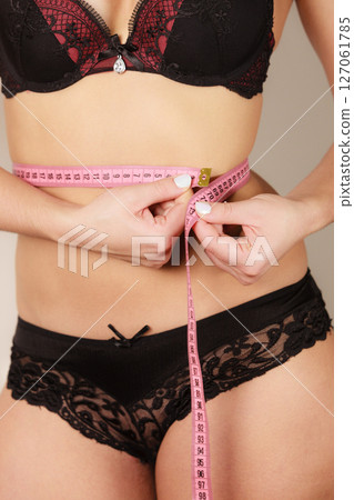 Woman measuring her waist closeup 127061785