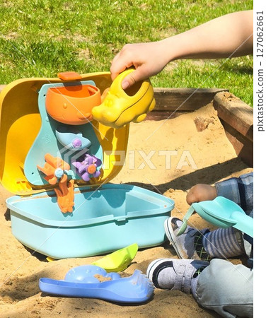 Children Playing in Backyard Sandbox with Colorful Toys Children Playing in Backyard Sandbox with Colorful Toys 127062661