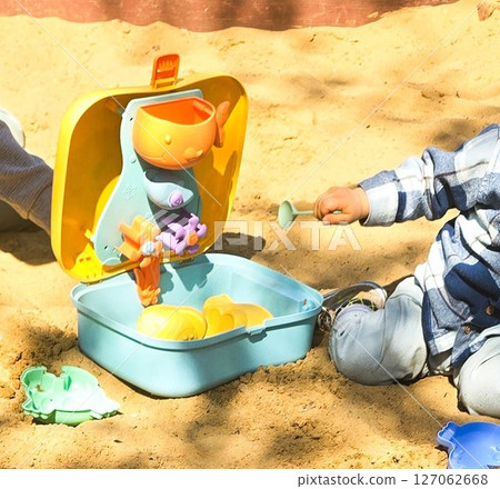 Children Playing in Backyard Sandbox with Colorful Toys 127062668
