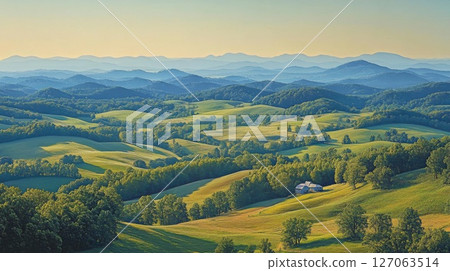 A lone farmhouse nestled in rolling hills and distant mountains 127063514