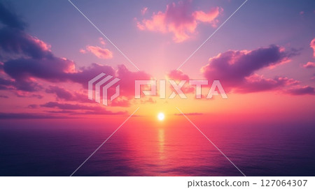 A breathtaking sunset over a tranquil ocean, showcasing vibrant pink and purple hues in the sky and water. 127064307