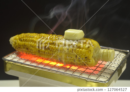 Cooking corn butter on a smoking charcoal grill 127064527