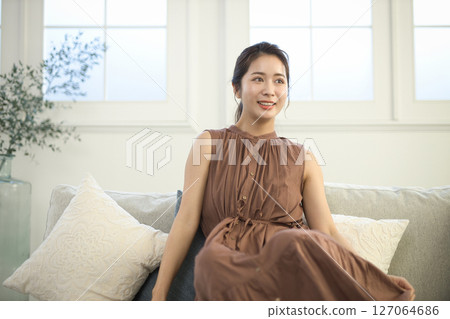 A woman in her 20s sitting on a sofa, beauty image 127064686