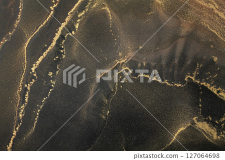 Abstract patterns created using alcohol ink on a dark surface showcase unique textures and colors 127064698