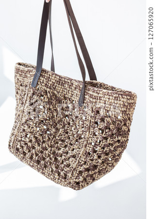 Female hand holding fashionable woven bag. Fashion and luxury accessories. Vertical photo. High quality photo 127065920