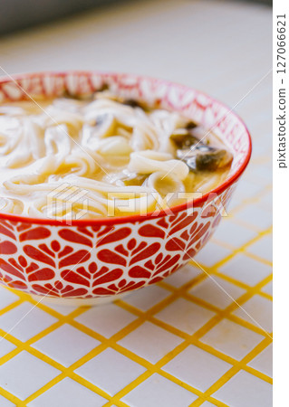 plate of noodles and chopsticks. vegetable ramen in a bright blue plate. Asian dishes. plate of noodles and chopsticks. vegetable ramen in a bright blue plate. Asian dishes. 127066621