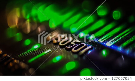 Close-up of electronic circuit board with glowing green lights and intricate details showcasing technology 127067034