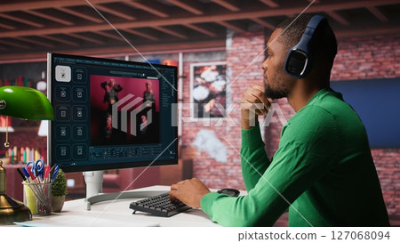 Black graphic designer working in loft with AI image generator software. Digital screen displaying visuals created through machine learning and cloud computing, generative AI. Camera B. Black graphic designer working in loft with AI image generator software. Digital screen displaying visuals created through machine learning and cloud computing, generative AI. Camera B. 127068094