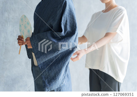 Staff helping foreign tourists put on yukata 127069351