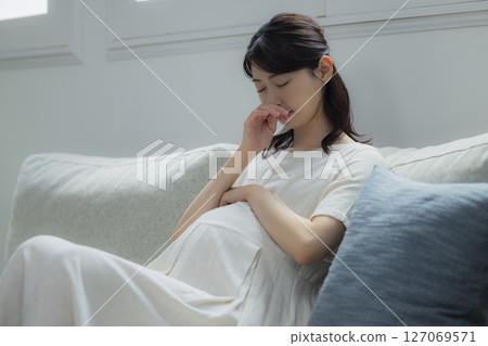 pregnant woman in the living room pregnant woman in the living room 127069571