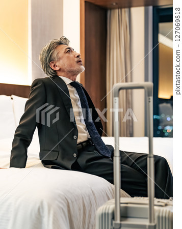 Middle-aged male business person relaxing in bed 127069818