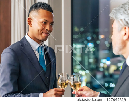 Multinational business people toasting with the city night view in the background Multinational business people toasting with the city night view in the background 127069819