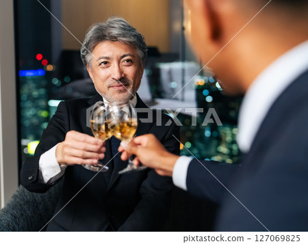 Multinational business people toasting with the city night view in the background Multinational business people toasting with the city night view in the background 127069825