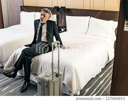放鬆在床上的中間男性商務人士 放鬆在床上的中間男性商務人士 127069853