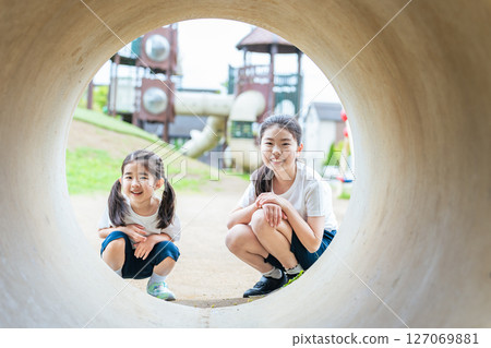 女孩們在公園裡看著隧道 女孩們在公園裡看著隧道 127069881