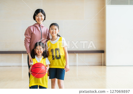 Children playing basketball and a female coach Children playing basketball and a female coach 127069897