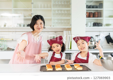 Girls and women baking bread 127069903