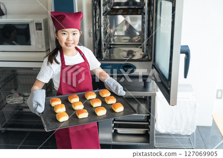 Girl baking cookies in the kitchen using the oven 127069905