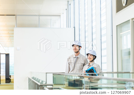 男性工程師和女工程師一邊查看平板電腦，一邊檢查建築物內部 127069907