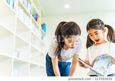 Girls reading books in the library 127069916