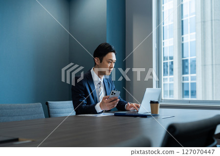 A businessman who uses a personal computer at the office 127070447