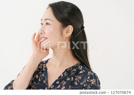 A smiling young woman with her hands on her cheeks 127070674
