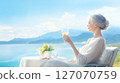 Gray-haired woman drinking wine on a terrace 127070759