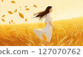 Woman walking through a wheat field in autumn 127070762
