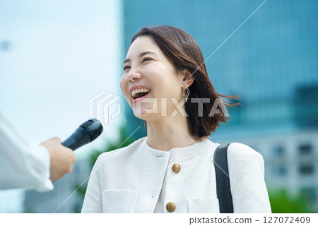 Young woman being interviewed outdoors 127072409