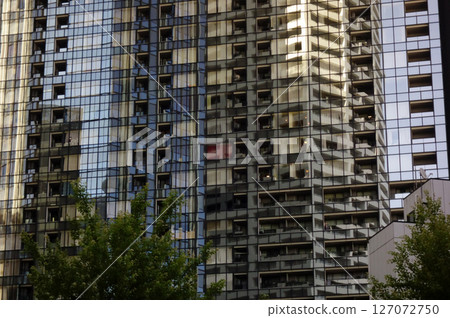 High-rise apartment building reflected in the windows of a skyscraper High-rise apartment building reflected in the windows of a skyscraper 127072750
