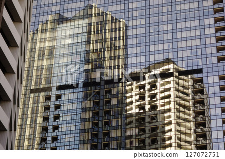 High-rise apartment building reflected in the windows of a skyscraper High-rise apartment building reflected in the windows of a skyscraper 127072751