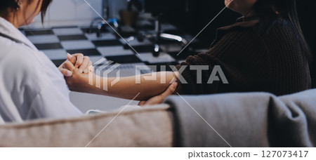 Orthopaedic doctor doing physical examination patient with wrist pain at the clinic. Physical therapist checks the patient wrist by pressing the wrist bone. 127073417