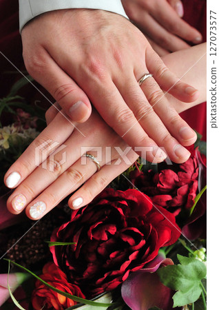 Wedding rings on the hands of the bride and groom holding hands 127073577