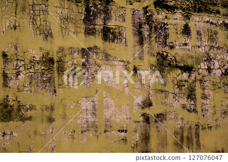 Cracked Yellow Paint with Dark Mold Creating Abstract Texture 127076047