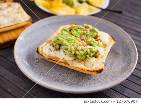 Healthy breakfast. toasted italian ciabatta bread with melted cheese and avocado puree Healthy breakfast. toasted italian ciabatta bread with melted cheese and avocado puree 127076907