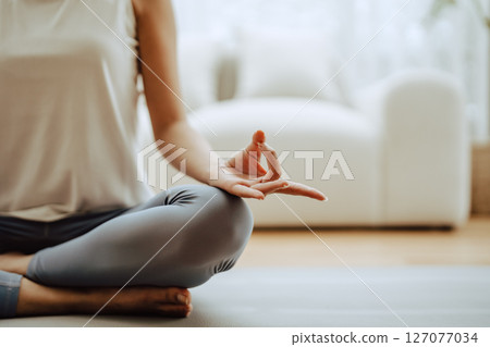 Close up hand of Asian woman practicing yoga and meditation at home Close up hand of Asian woman practicing yoga and meditation at home 127077034