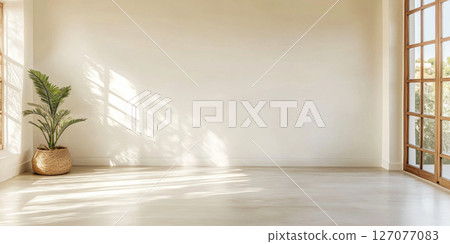 Bright and airy interior space with natural light and a potted plant in the corner 127077083
