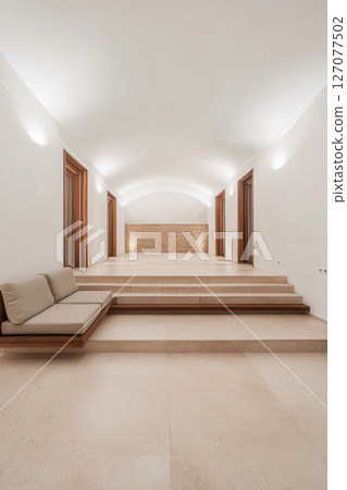 Modern minimalist interior design featuring steps and seating in a serene space Modern minimalist interior design featuring steps and seating in a serene space 127077502