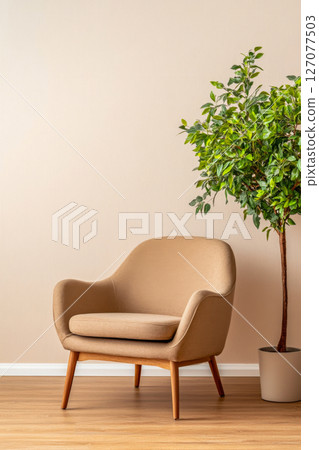 Cozy chair beside a potted plant against a light wall in a modern living space 127077503