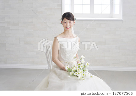 Woman in her 20s wearing a wedding dress, portrait, looking at camera Woman in her 20s wearing a wedding dress, portrait, looking at camera 127077566