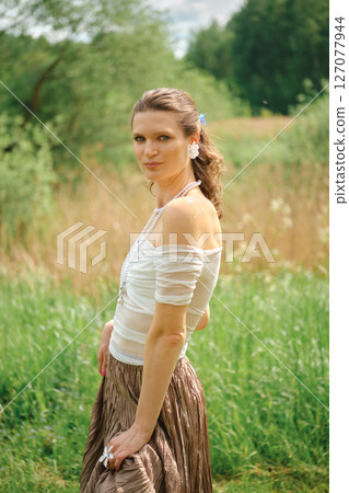 Woman in outdoor setting wearing casual clothing and accessories during a sunny day 127077944